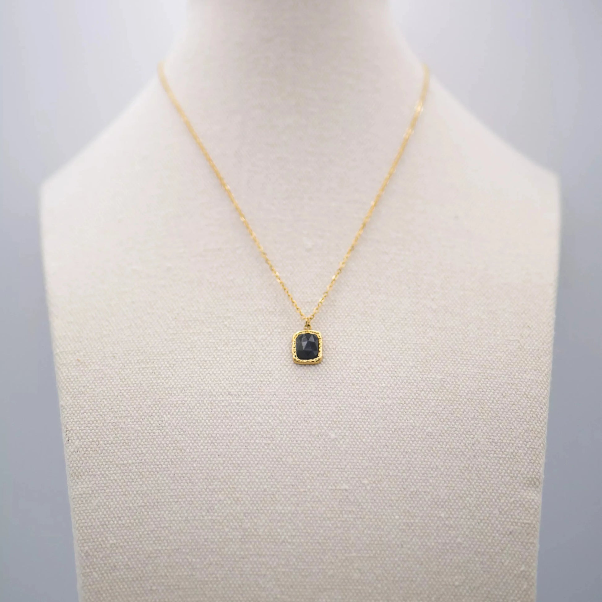 Colgante Módena en dorado con piedra negra cuadrada, estilo elegante.